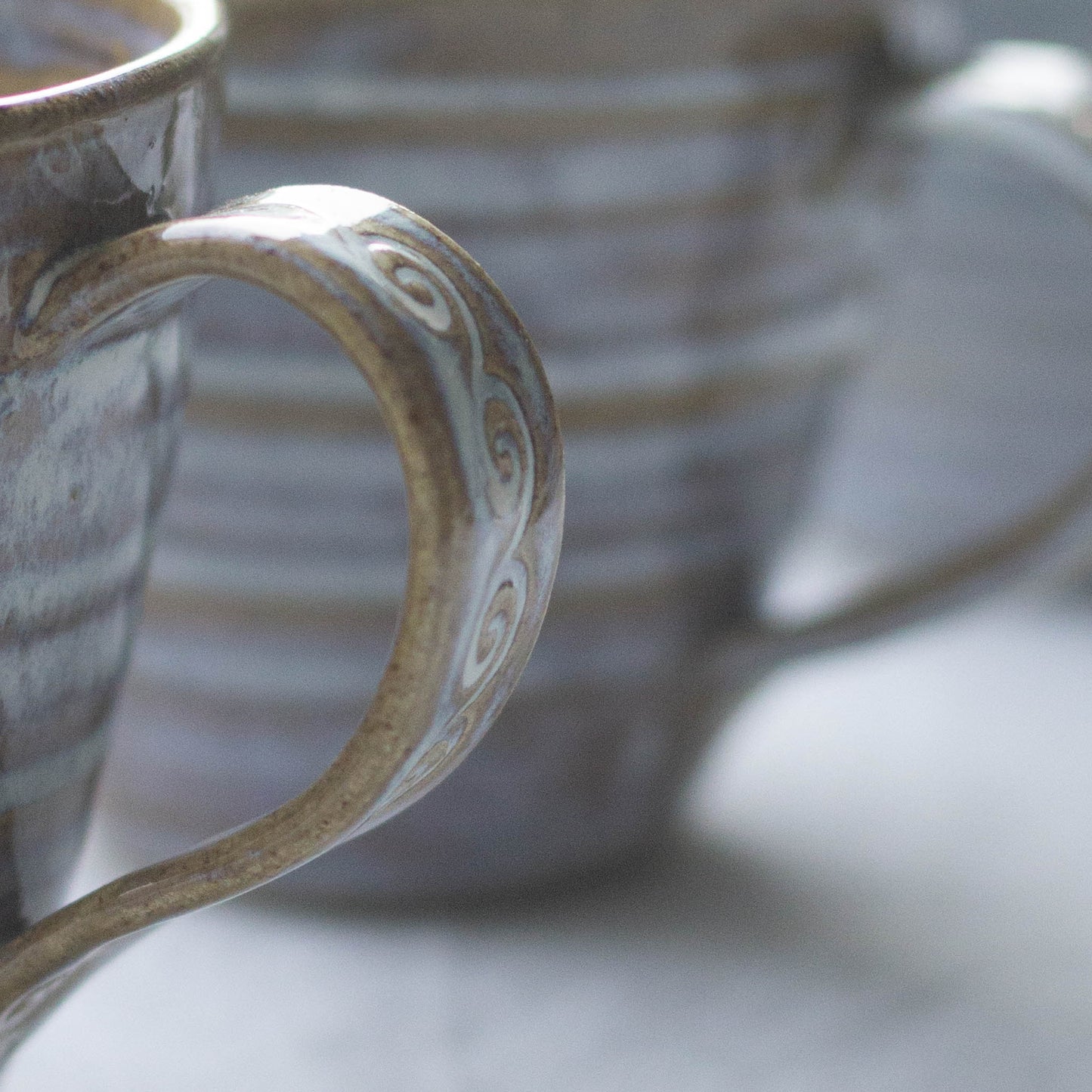 side angle view of decorative handle on a handmade ceramic coffee cup