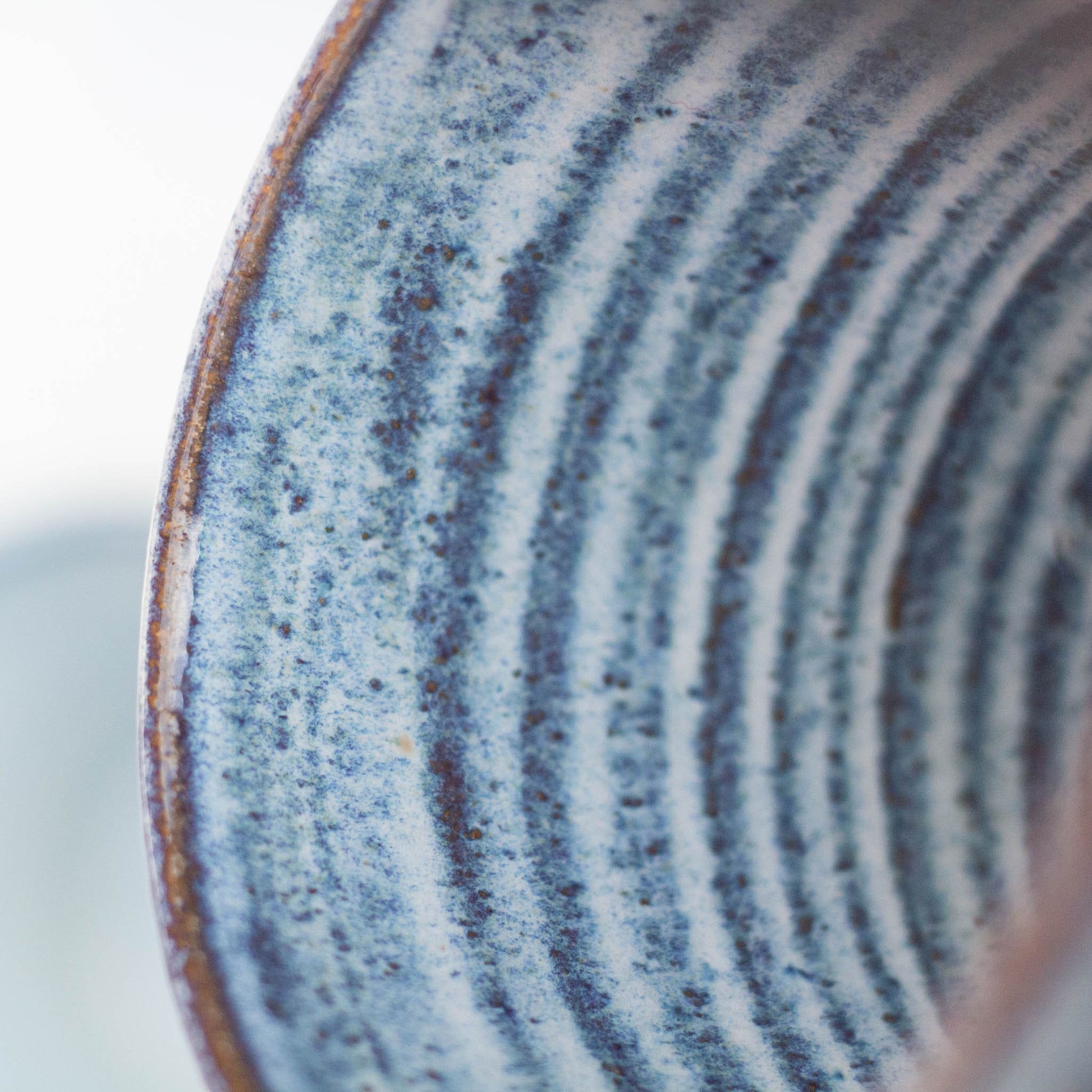 Close-up of a ceramic cup with blue and white glaze pattern