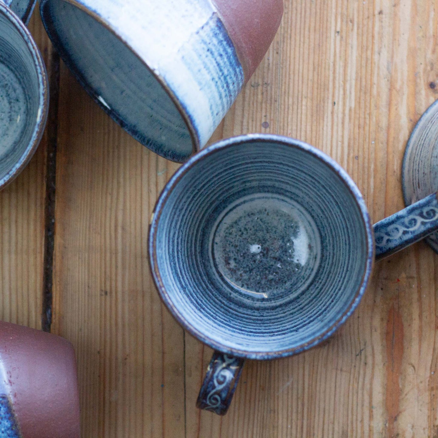 Ceramic mugs with textured design on a wooden surface