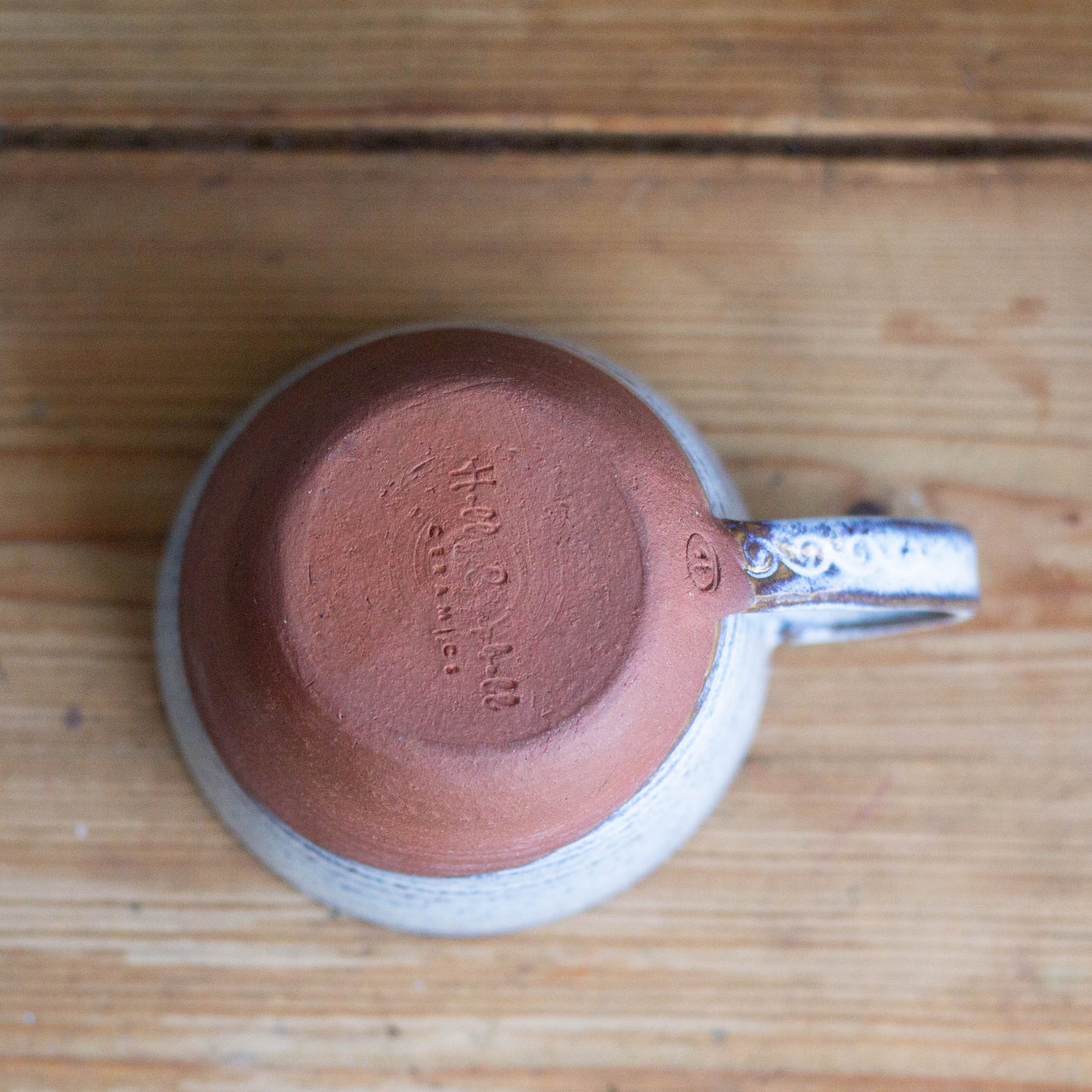 Ceramic cup upside down on a wooden table with with visible stamp 