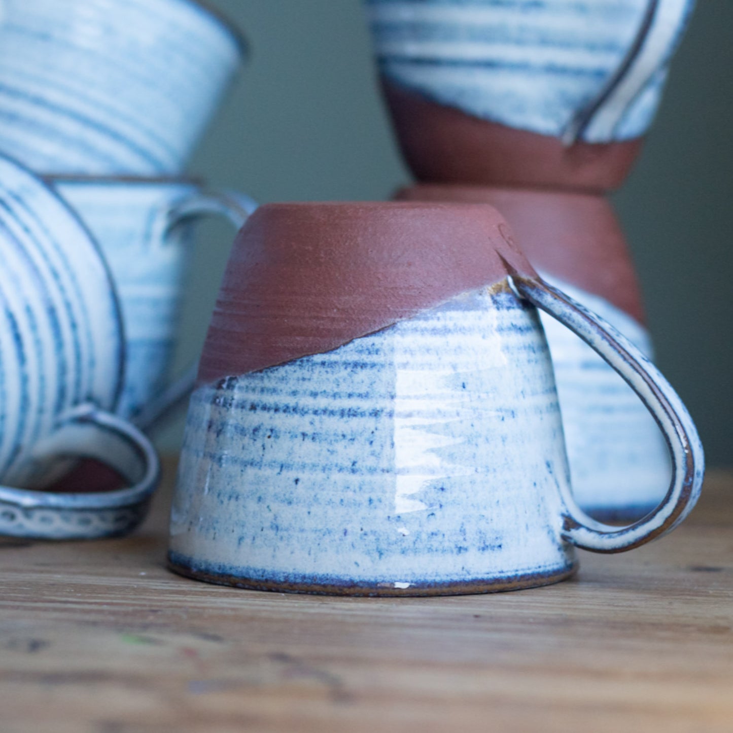 Ceramic mug with blue and white speckled glaze on a wooden surface